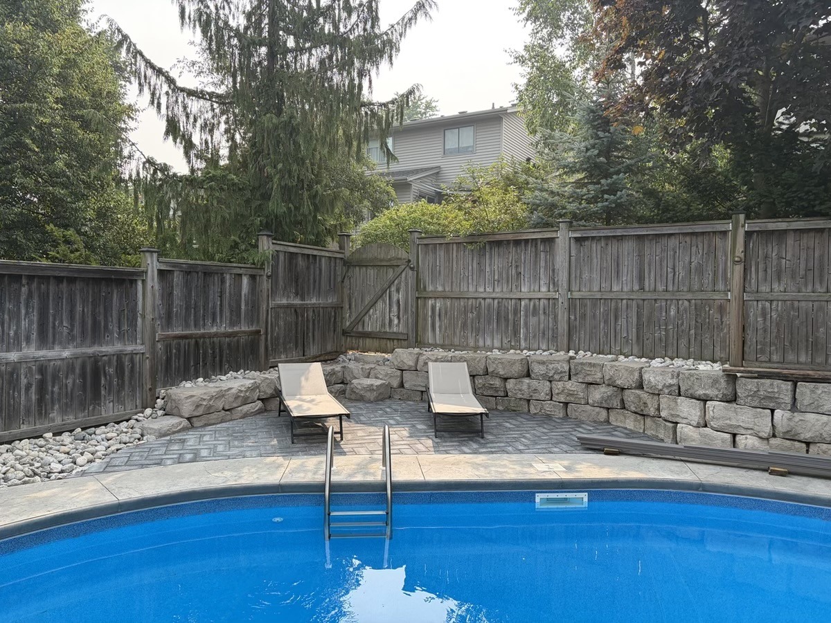 Pool patio framed by a retaining wall and stone work