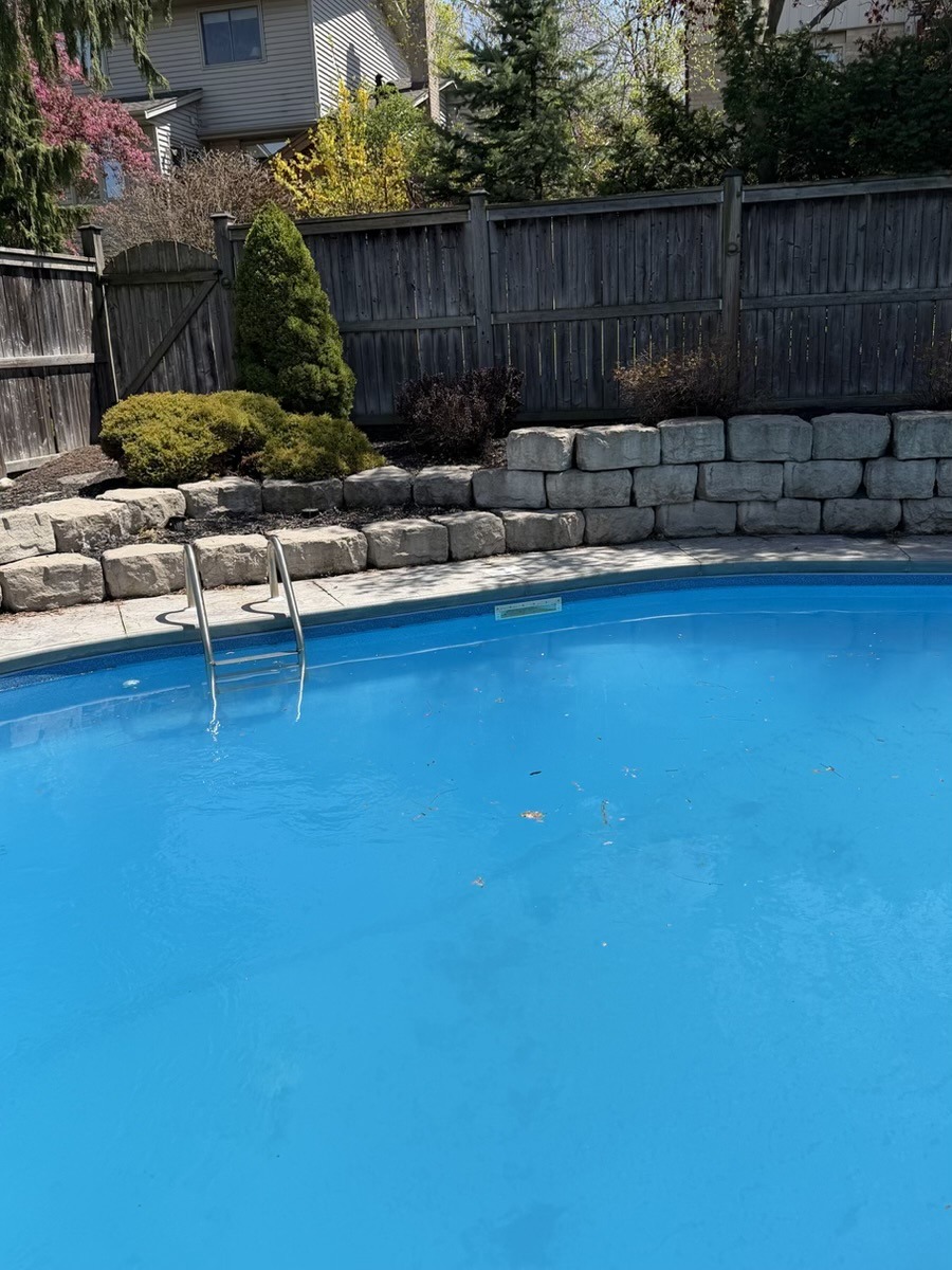 Stone retaining wall detail beside a completed pool